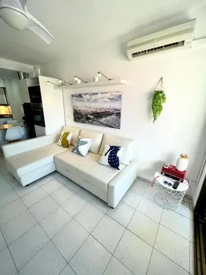 a living room with a white couch in a room at Apartemento piscina centro calella 3 min playa in Calella
