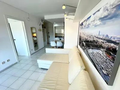 a living room with a couch and a painting on the wall at Apartemento piscina centro calella 3 min playa in Calella