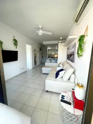 a living room with a couch and a tv at Apartemento piscina centro calella 3 min playa in Calella