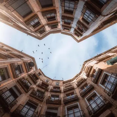 a group of birds flying in the sky through a building at TOC Hotel Las Ramblas in Barcelona