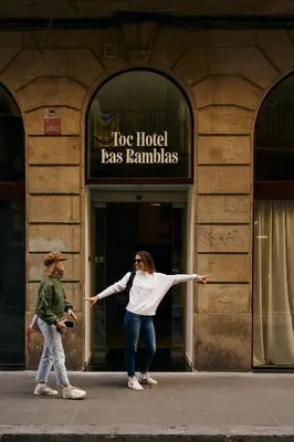 a woman standing in front of a building with her arms out at TOC Hotel Las Ramblas in Barcelona