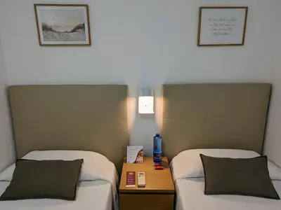 two beds sitting next to each other in a room at Hostal Alogar in Barcelona