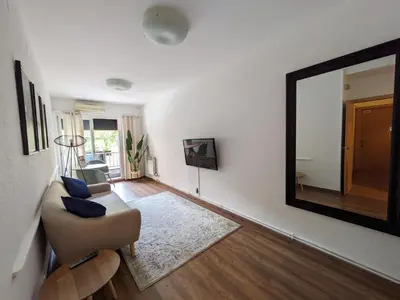 a living room with a mirror and a chair at Hostal Alogar in Barcelona