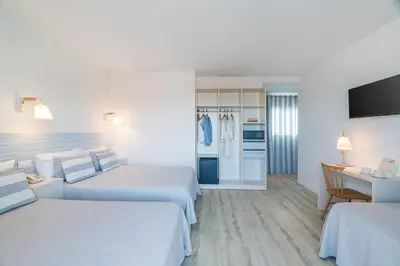 a hotel room with two beds and a kitchen at FERGUS Club Pineda Splash in Pineda de Mar