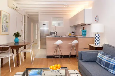 a living room and kitchen with a couch and a table at Click&Flat Stylish Torrijos in Barcelona