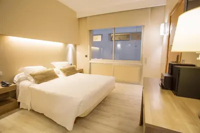 a bedroom with a white bed and a television at Aparthotel Silver in Barcelona