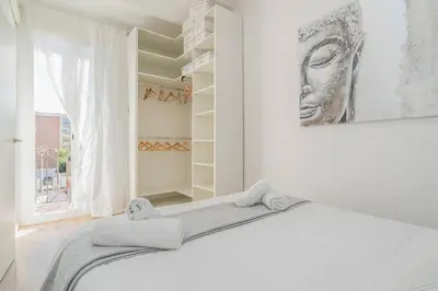 a white room with a bed and a large window at Fira BOUTIQUE by MyRentalHost in Hospitalet de Llobregat