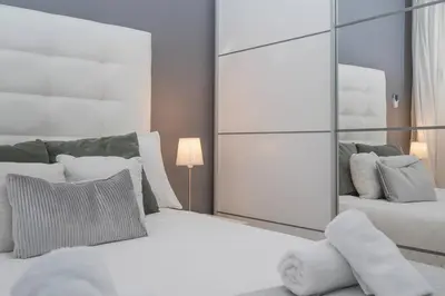 a bedroom with two white beds and a mirror at Fira BOUTIQUE by MyRentalHost in Hospitalet de Llobregat