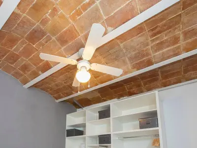 a ceiling fan in a room with a brick wall at Colour Pop FIRA by MyRentalHost in Hospitalet de Llobregat