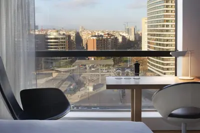 a room with a desk and a view of a city at Barceló Sants in Barcelona