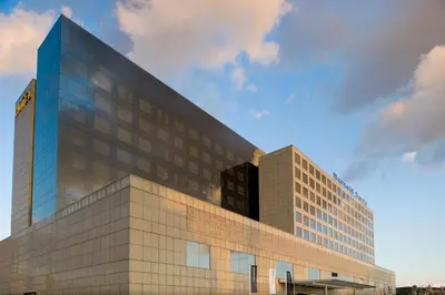 a tall glass building with a sky at Barceló Sants in Barcelona