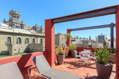 a balcony with chairs and tables and a view of a building at Hotel Gótico in Barcelona