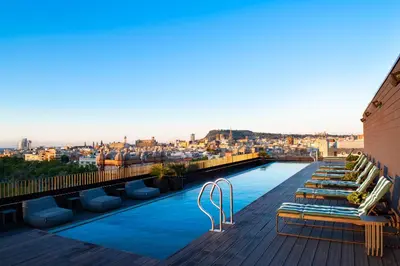 a rooftop patio with couches and tables on a building at Archie Living in Barcelona