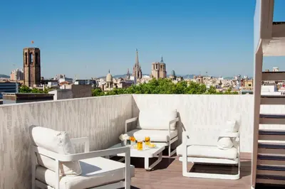 a patio with two chairs and a table on a balcony at Gaudi Hotel in Barcelona