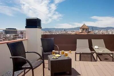 a balcony with chairs and a table on a roof at Gaudi Hotel in Barcelona