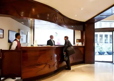 three people standing at a bar in a restaurant at Gaudi Hotel in Barcelona