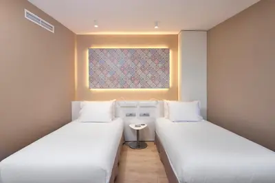 two beds in a small room with a window at Eurostars Don Cándido in Terrassa