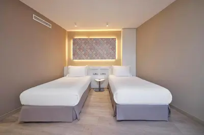 two beds in a small room with a window at Eurostars Don Cándido in Terrassa
