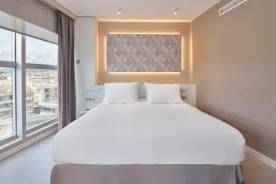 a bedroom with a large white bed and a window at Eurostars Don Cándido in Terrassa