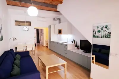 a living room with a blue couch and a table at Acogedor apartamento con entrada independiente in Barcelona