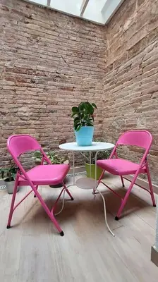 two pink chairs and a table in a room at Acogedor apartamento con entrada independiente in Barcelona