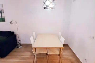 a dining room with a white table and chairs at Acogedor apartamento con entrada independiente in Barcelona