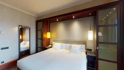 a bedroom with a large white bed and a mirror at Hotel Barcelona Center in Barcelona