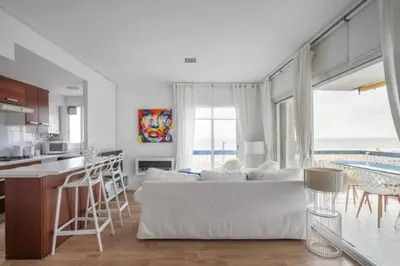a living room with a white couch and a kitchen at Sunset Boutique Castelldefels by MyRentalHost in Castelldefels