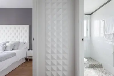 a white bedroom with a bed and a bathroom at Sunset Boutique Castelldefels by MyRentalHost in Castelldefels