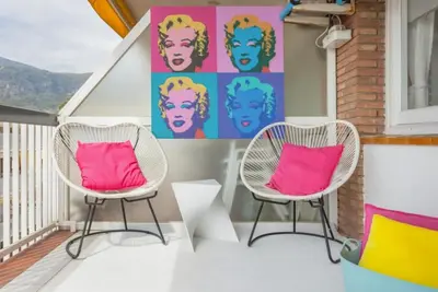 two chairs sitting on a porch with pink pillows at Sunset Boutique Castelldefels by MyRentalHost in Castelldefels