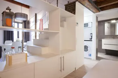 a kitchen with white cabinets and a washing machine at Habitat Apartments Alissia in Barcelona