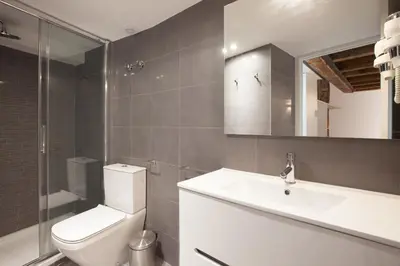 a bathroom with a toilet and a sink and a mirror at Habitat Apartments Alissia in Barcelona