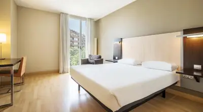 a bedroom with a large white bed and a desk at Ilunion Auditori in Barcelona