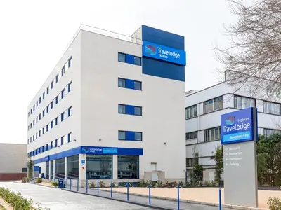 a large white building with a sign in front of it at Travelodge Barcelona Fira in Hospitalet de Llobregat