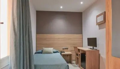 a bedroom with a bed and a desk with a computer at Ramblas Hotel in Barcelona