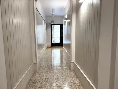 a hallway with white walls and a tile floor at Click&Flat Rizal in Barcelona