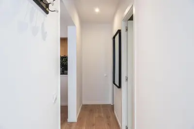 a hallway with white walls and wood floors at Design and comfort in the trendy neighborhood in Barcelona