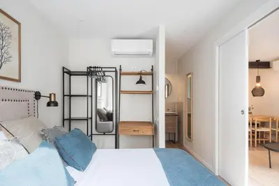 a bedroom with a white bed and a table at Style and design in the best location, Eixample Barcelona in Barcelona