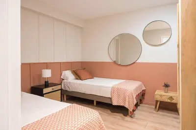 a bedroom with two beds and two mirrors at Style and design in the best location, Eixample Barcelona in Barcelona