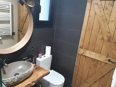 a bathroom with a sink and a wooden door at Lucky House in Badalona