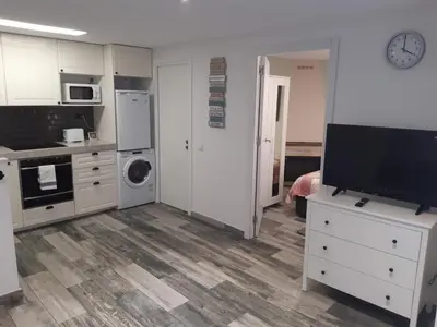 a kitchen with white cabinets and a tv in it at Lucky House in Badalona