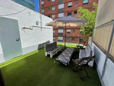 a patio with a table and chairs and an umbrella at Lucky House in Badalona