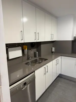 a kitchen with white cabinets and a sink at La Llum de Sitges in Sitges