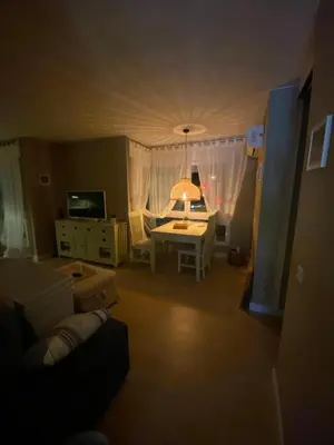 a living room with a couch and a table with a lamp at Cardedeu City and Circuit apartment in Cardedeu