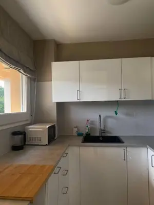 a kitchen with white cabinets and a sink and a window at Cardedeu City and Circuit apartment in Cardedeu