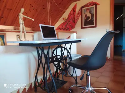 a desk with a laptop and a chair at Chalet Entre Parques Naturales in Vallgorguina