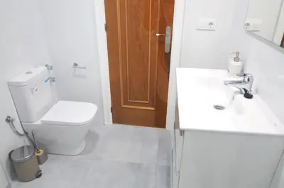 a white bathroom with a toilet and a sink at HomeHolidaysRentals SantMartin - Costa Barcelona in Calella
