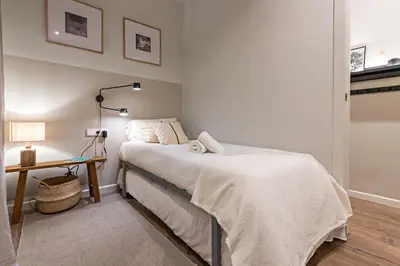 a bedroom with a bed and a table with a lamp at Habitat Apartments Sweet Sagrada Familia in Barcelona