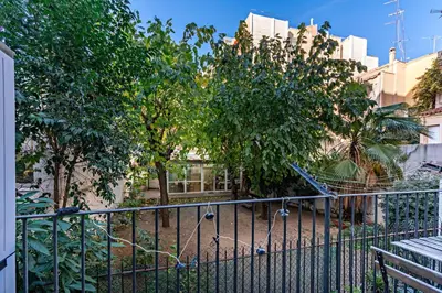 a playground behind a fence with trees and buildings at Habitat Apartments Sweet Sagrada Familia in Barcelona