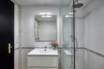 a white bathroom with a sink and a shower at BBarcelona Parallel Apartment in Barcelona
